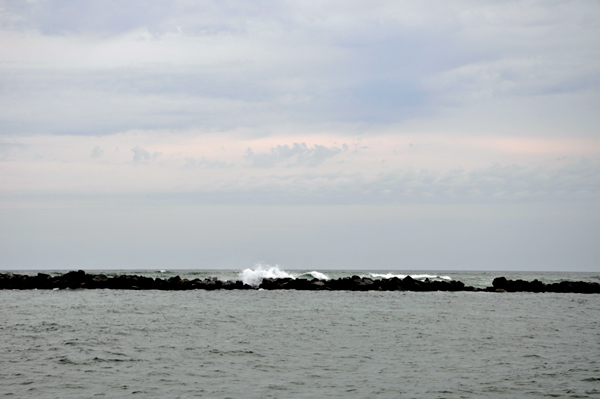 The waves were breaking high over the nearby jetty